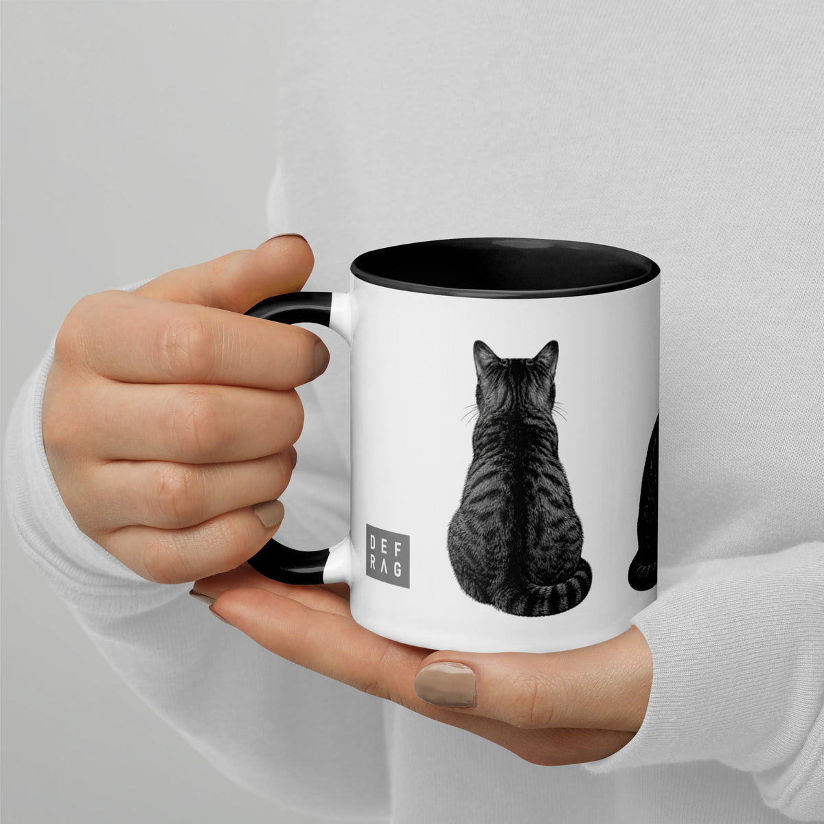 猫の後ろ姿が見えるマグカップを手に持った使用イメージ